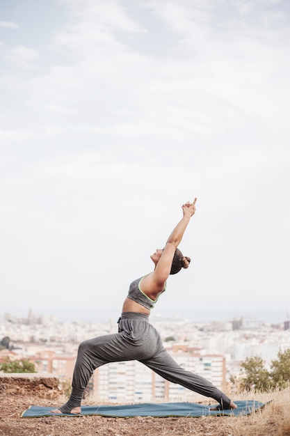 Vista laterale della donna che fa yoga