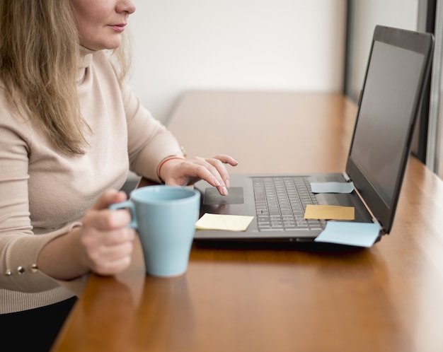 Vista laterale della donna che lavora al computer portatile all'ufficio