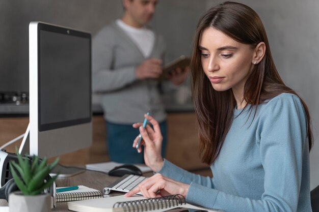 Vista laterale della donna che lavora nel campo dei media con personal computer