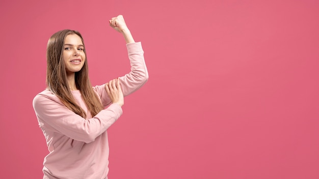 Vista laterale della donna che mostra il suo bicipite