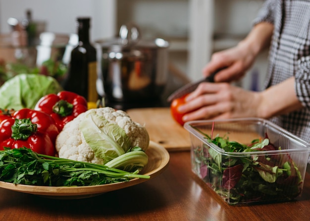 Vista laterale della donna che prepara il cibo in cucina