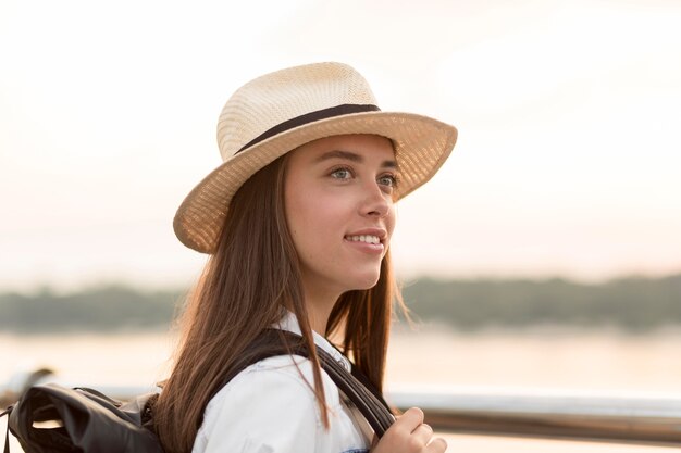 Vista laterale della donna con il cappello in posa durante il viaggio