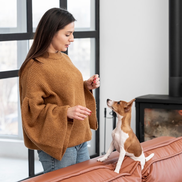 Vista laterale della donna con il suo cane sul divano