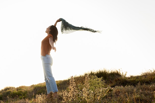 Vista laterale della donna con la sciarpa all'aperto