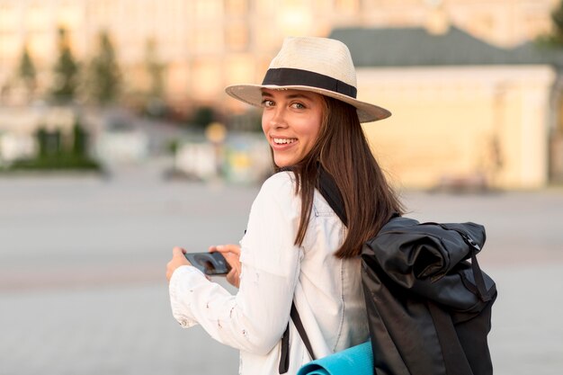 Vista laterale della donna con zaino e cappello mentre si viaggia da soli