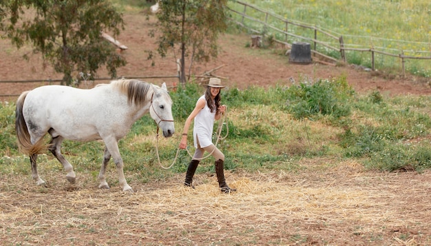 Vista laterale della donna contadina con il suo cavallo