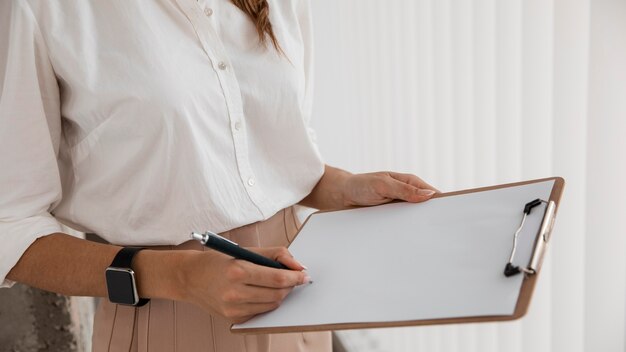 Vista laterale della donna di affari con i appunti