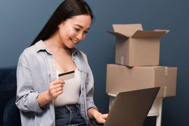 Vista laterale della donna di smiley che fa un certo acquisto online