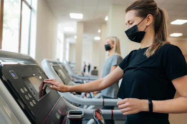 Vista laterale della donna in palestra durante la pandemia