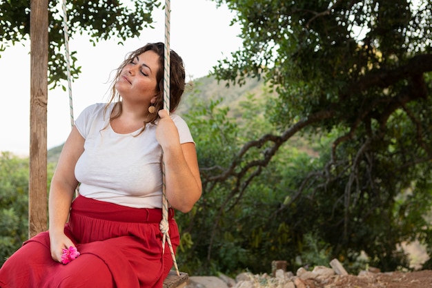 Vista laterale della donna seducente all'aperto nell'oscillazione