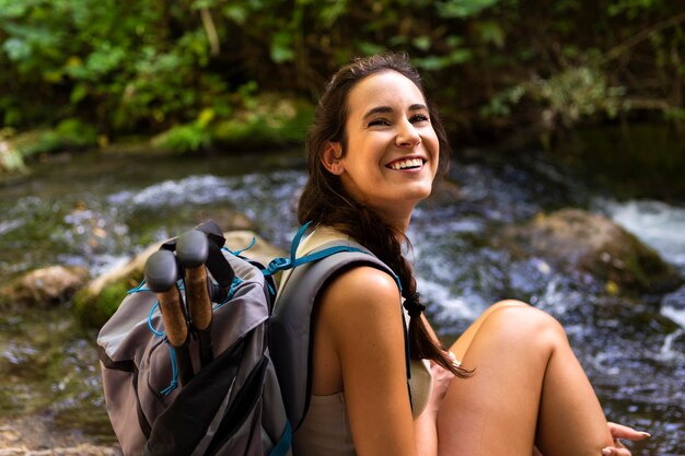 Vista laterale della donna sorridente su un'esplorazione della natura