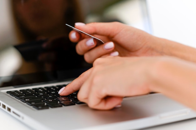 Vista laterale della donna sul computer portatile con acquisti con carta di credito su cyber lunedì