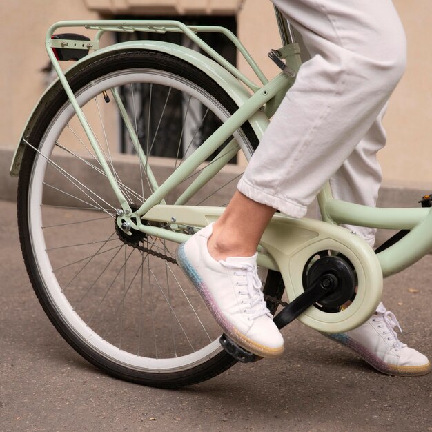 Vista laterale della donna sulla sua bicicletta in città