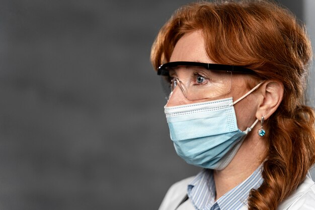 Vista laterale della dottoressa con maschera medica e copia spazio