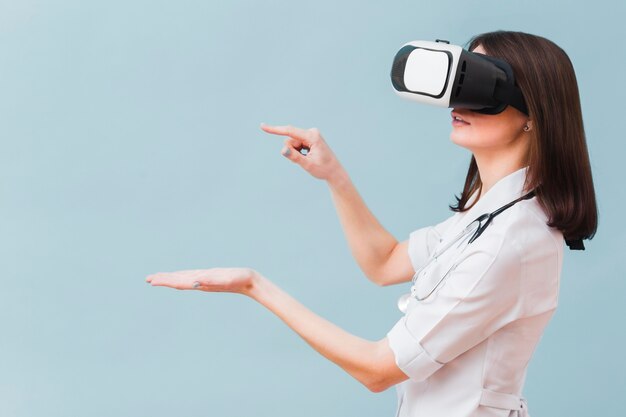 Vista laterale della dottoressa sperimentando la realtà virtuale