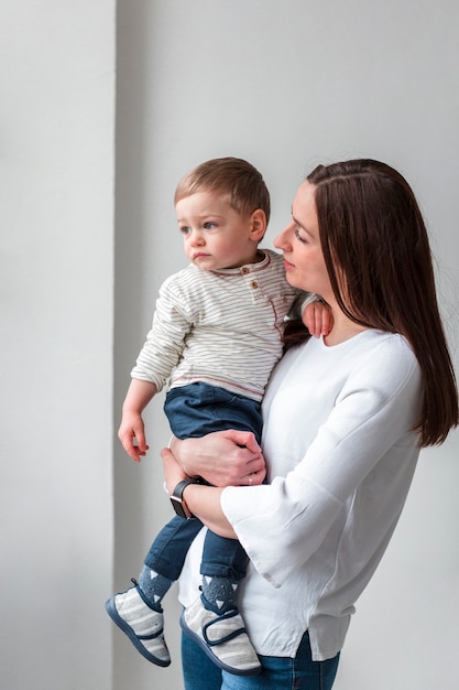 Vista laterale della madre che tiene il bambino