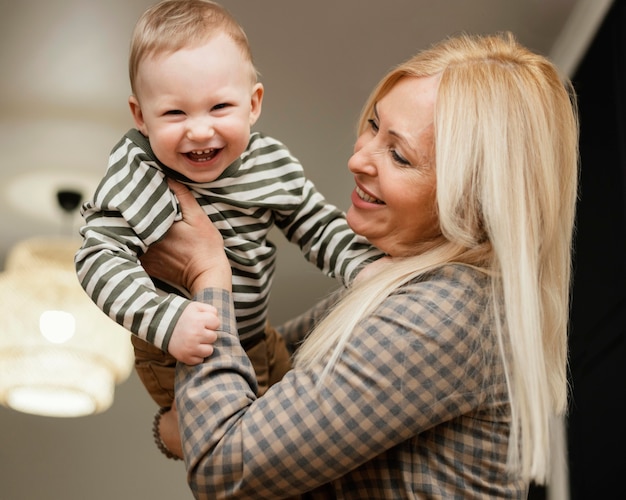 Vista laterale della nonna sorridente che tiene il suo nipote