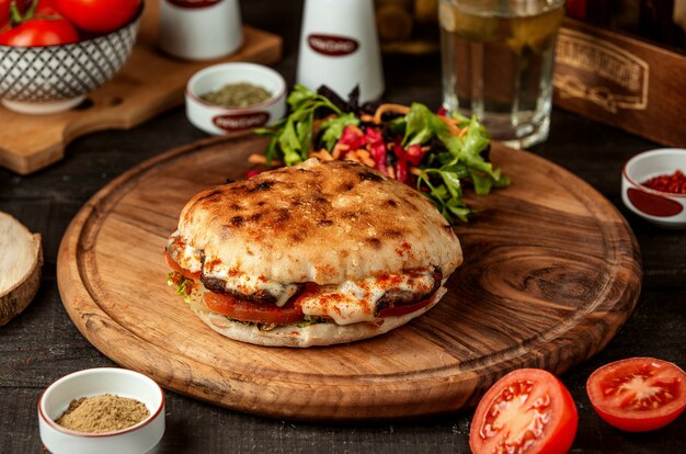 Vista laterale della pita con carne e verdure sul bordo di legno