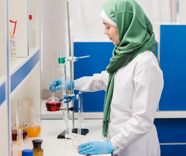 Vista laterale della scienziata con hijab in laboratorio