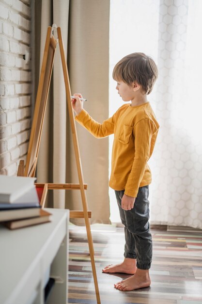 Vista laterale della scrittura del bambino sulla lavagna