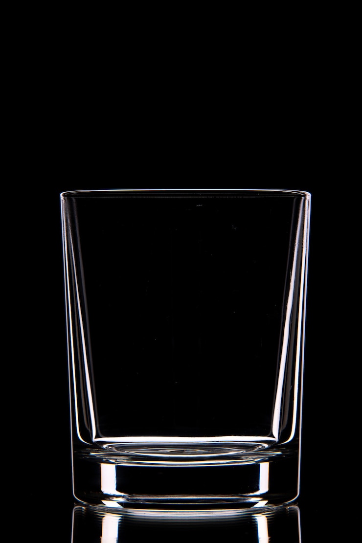 Foto gratuito vista laterale della tazza di vetro vuota sulla parete scura con spazio libero