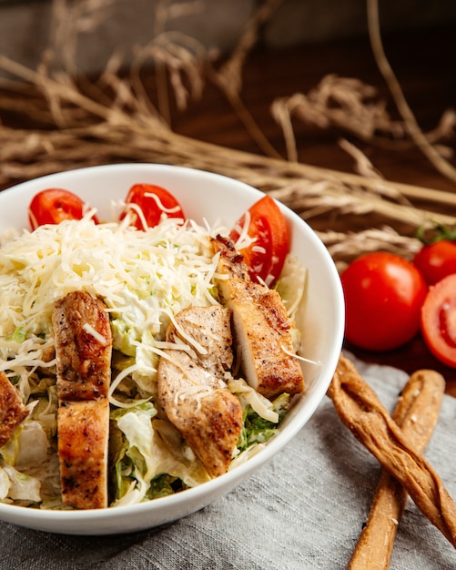 Vista laterale delle acciughe del pomodoro del formaggio della lattuga del pollo di Caesar