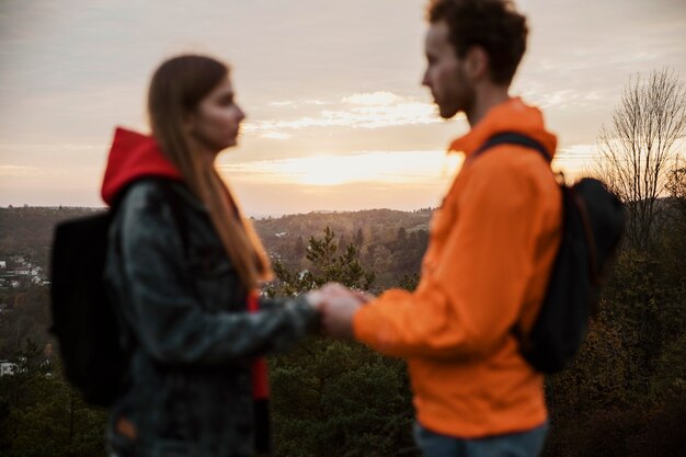Vista laterale delle coppie che tengono le mani al tramonto durante un viaggio