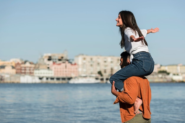 Vista laterale delle coppie romantiche che godono della vista della spiaggia