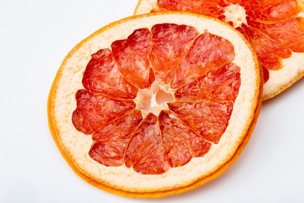 Vista laterale delle fette arancio secche isolate su fondo bianco