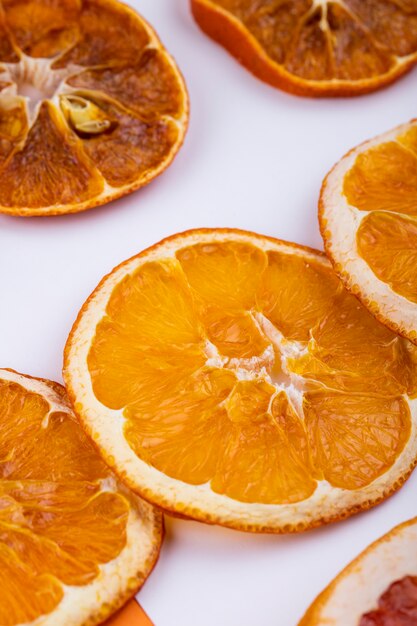 Vista laterale delle fette arancio secche su fondo bianco