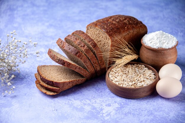 Vista laterale delle fette di pane nero farina d'avena uova su sfondo blu ghiaccio chiaro con spazio libero