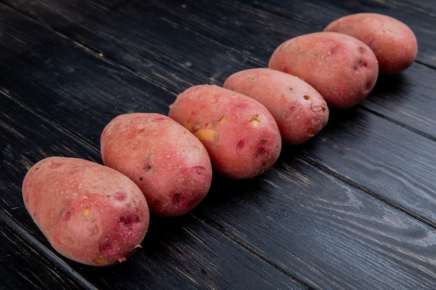 Vista laterale delle patate rosse sulla tavola di legno