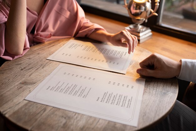 Vista laterale delle persone con i menu al ristorante