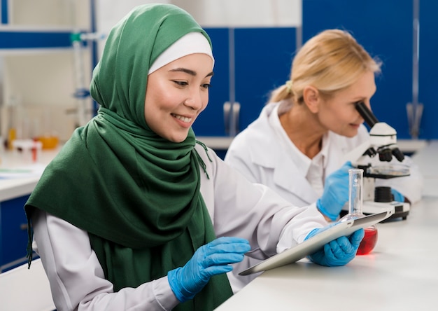 Vista laterale delle scienziate in laboratorio che lavorano insieme