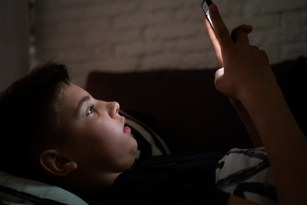 Vista laterale dello smartphone della tenuta del bambino