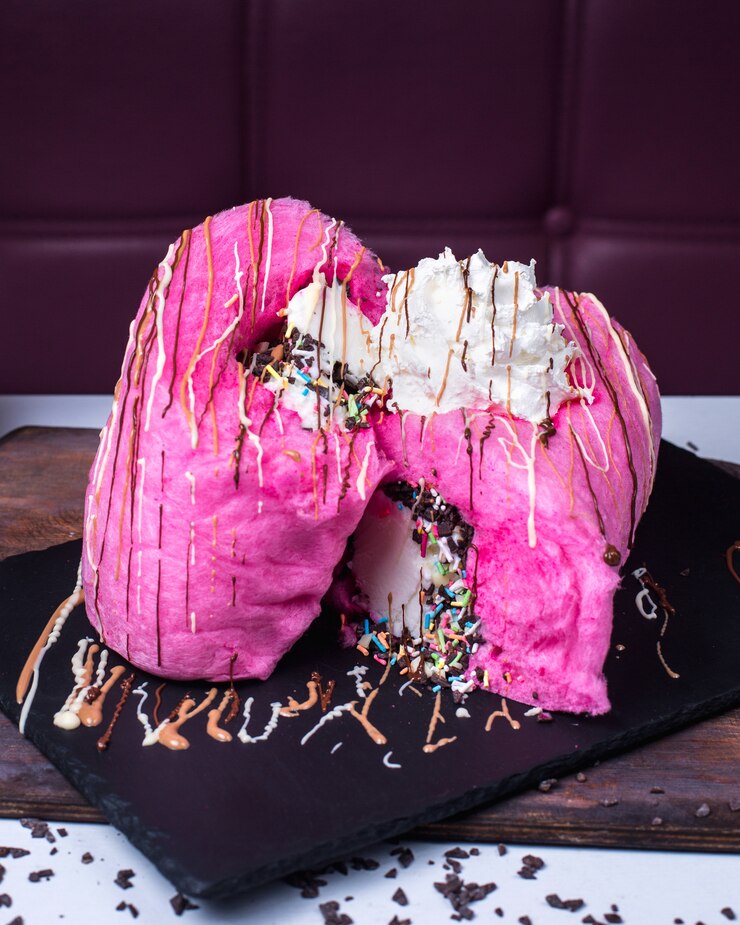 Foto gratuito vista laterale dello zucchero filato rosa con panna montata sul bordo nero