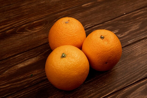 vista laterale di arance fresche mature isolate su superficie di legno