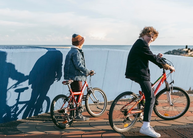 Vista laterale di bambini che vanno in bicicletta all'aperto