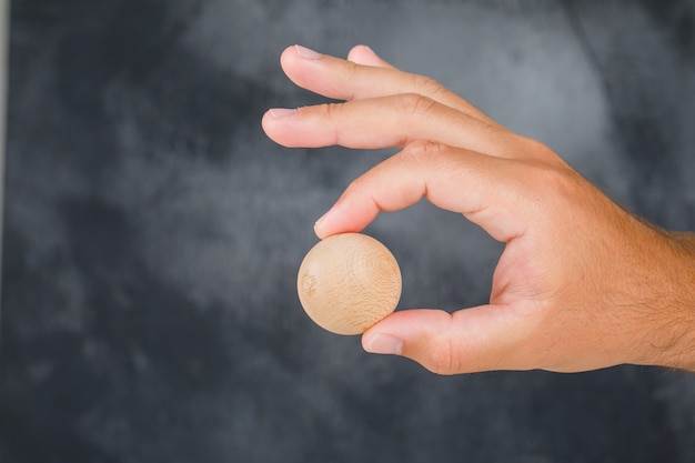 Vista laterale di concetto di strategia aziendale. mano che tiene la sfera di legno.