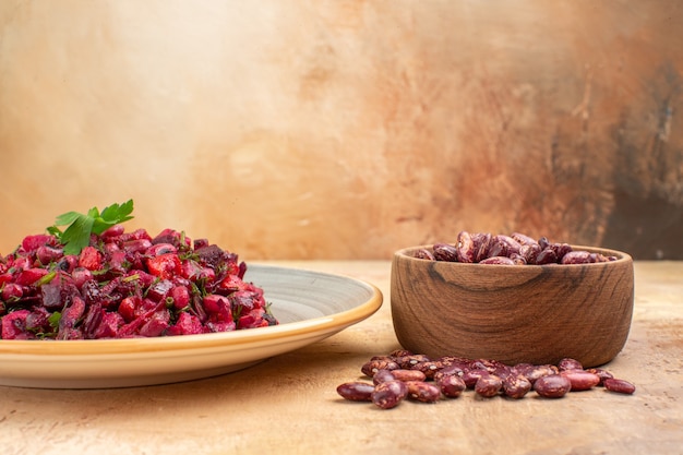 Vista laterale di deliziosa insalata con barbabietola e fagioli e fagioli dentro e fuori la pentola su sfondo di colore misto