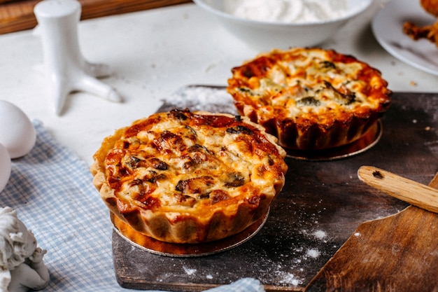 Vista laterale di mini torta con carne e verdure su un tagliere di legno