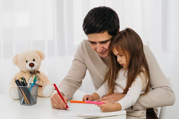 Vista laterale di padre e figlia a casa insieme