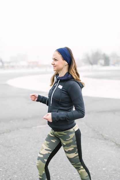 Vista laterale di un atleta femminile che si esercita in inverno