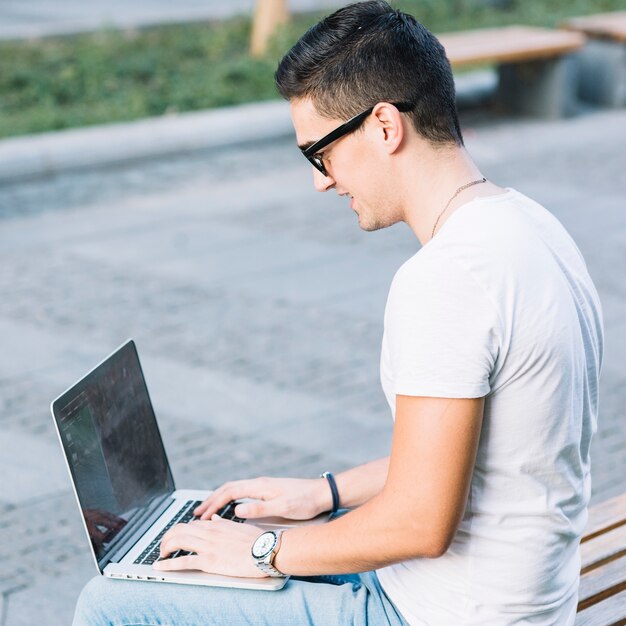 Vista laterale di un giovane che lavora al computer portatile