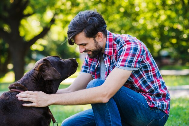 Vista laterale di un giovane uomo che guarda il suo cane