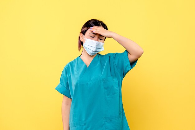 Vista laterale di un medico in maschera un medico in maschera è stanco dopo aver trattato i pazienti