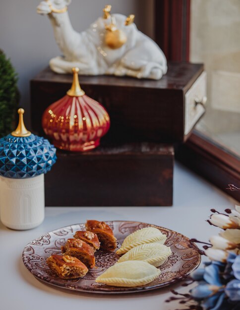 Vista laterale di un piatto con il nazionale azero pakhlava e shekarbura come simbolo di novruz