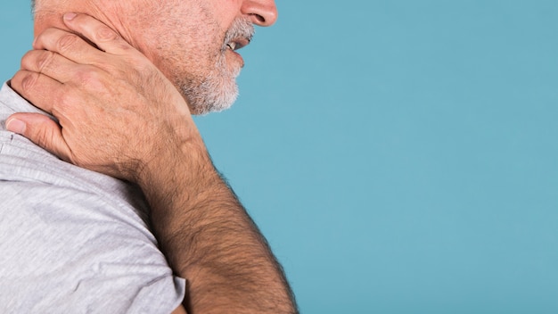 Vista laterale di un uomo anziano che soffre di dolore al collo