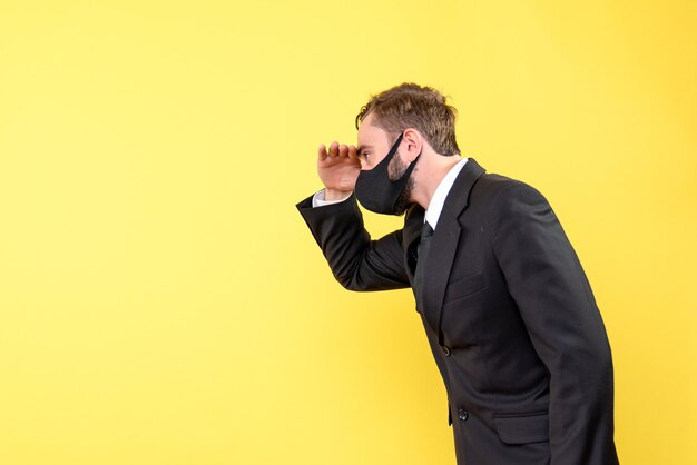 Vista laterale di un uomo che pensa con giacca e cravatta mettendo la mano sulla fronte con il giallo