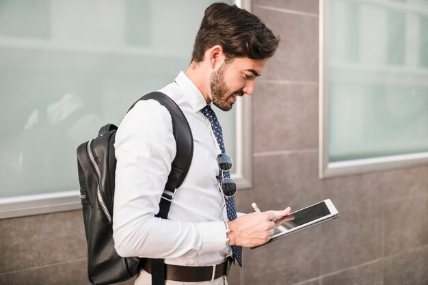 Vista laterale di un uomo che utilizza la tavoletta digitale